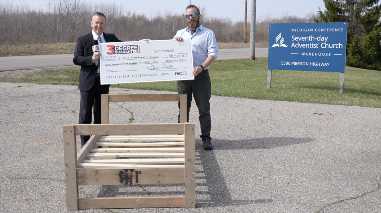 FOX 47 General Manger Gary Baxter presents check for $1,450 to Sleep in Heavenly Peace Lansing Chapter President Jarrod Olsen