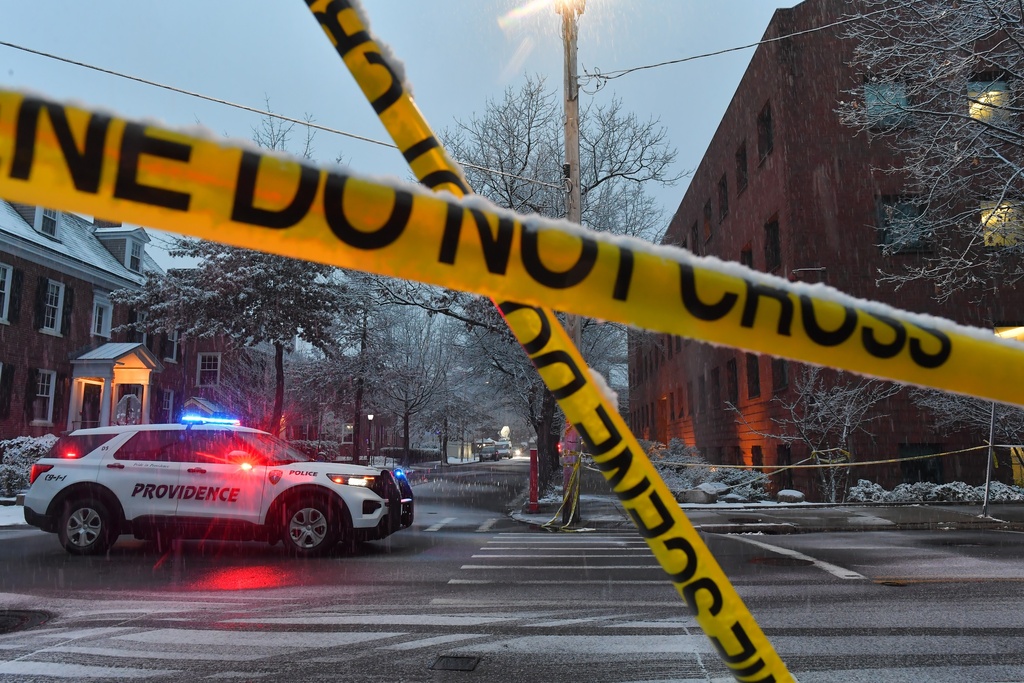 A police vehicle is parked at an intersection near crime scene tape at Brown University, Sunday, Dec. 14, 2025, in Providence, R.I., following a Saturday shooting at the university.