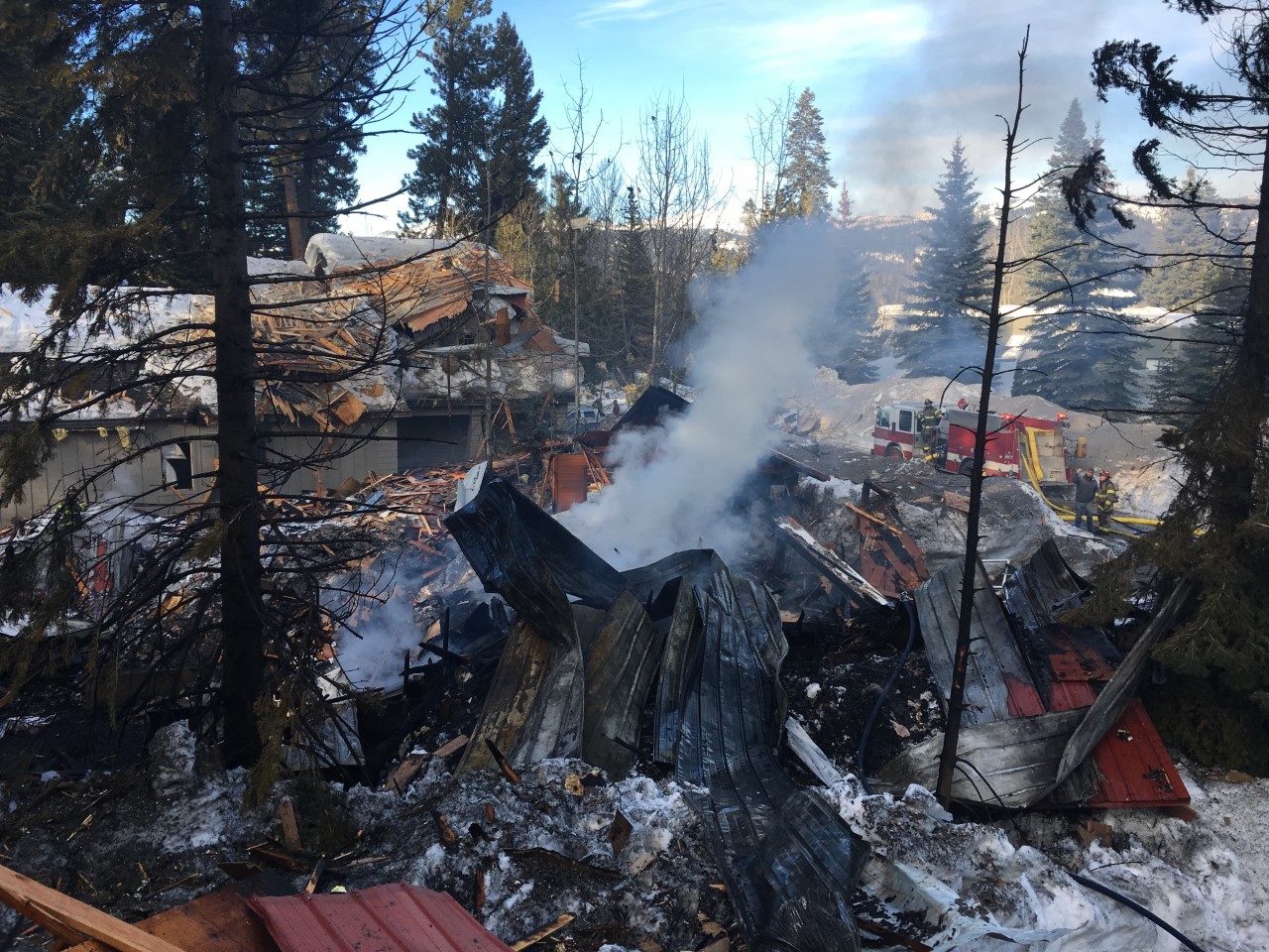 Firefighters take in the blast site of a residence that exploded Sunday