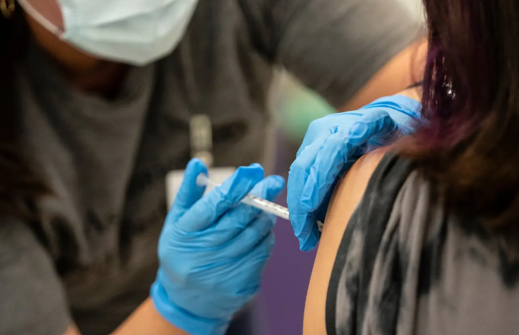 A nurse administers a dose of the Pfizer COVID vaccine at a clinic organized by the Travis County Mobile Vaccine Collaborative at Rodriguez Elementary School on July 28, 2021.