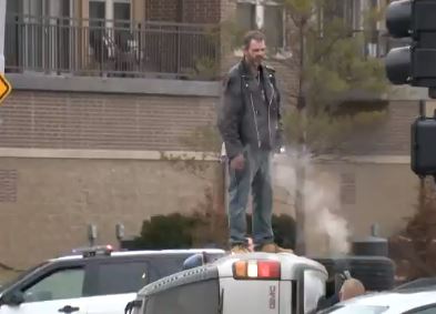 man on top of suv 64 and center
