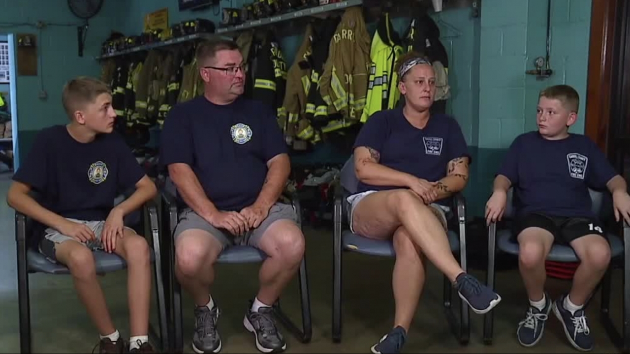 A family of four who lost their home to a fire sits in a fire station