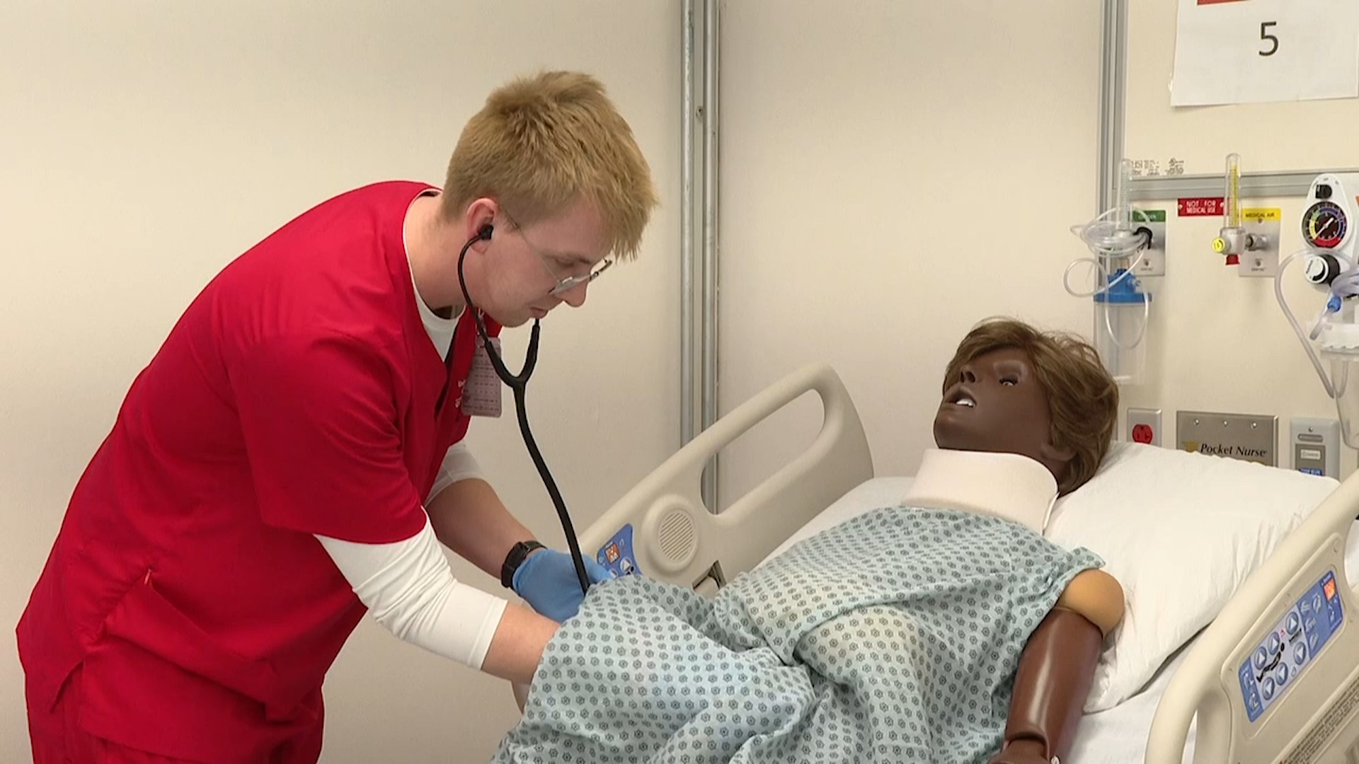 Nursing student practicing on dummy.