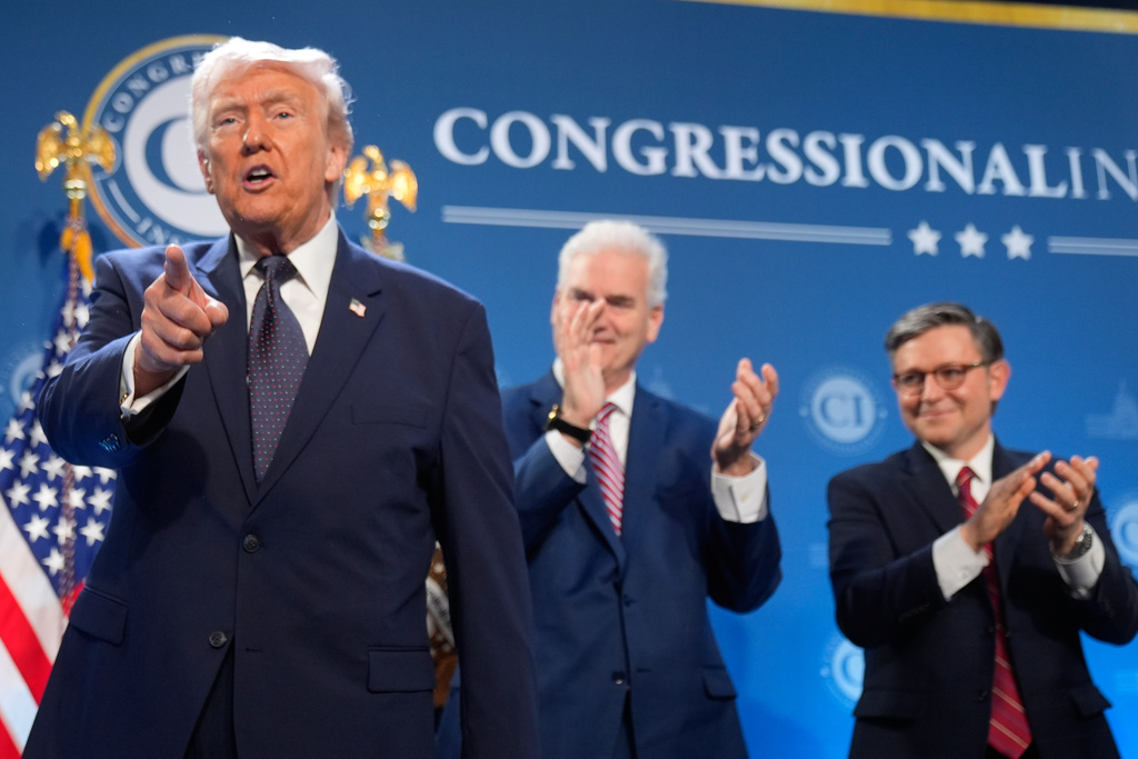 President Donald Trump gestures as Rep. Tom Emmer, R-Minn., and House Speaker Mike Johnson of La., applaud at the Republican Members Issues Conference, Monday, March 9, 2026, at Trump National Doral Miami in Doral, Fla. 