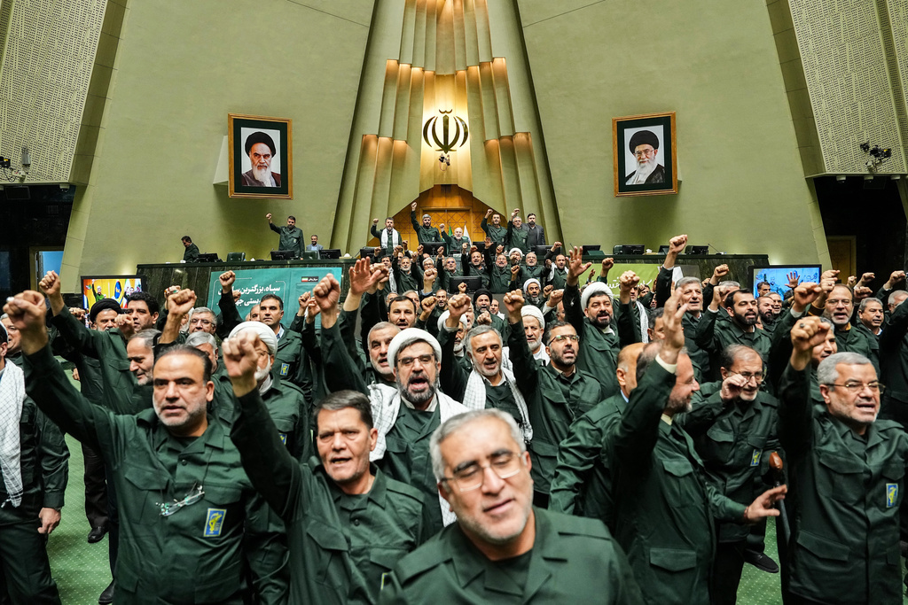 In this handout photo released by the Islamic Consultative Assembly News Agency (ICANA) Iranian lawmakers chant slogans as they wear the Revolutionary Guard's uniform in a session of parliament, in Tehran, Iran, Sunday, Feb. 1, 2026.