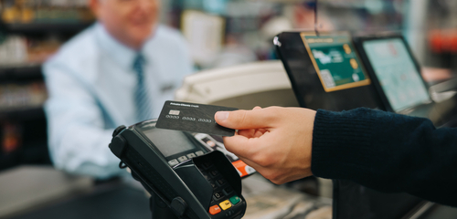 Stock image of a person paying with a credit card.