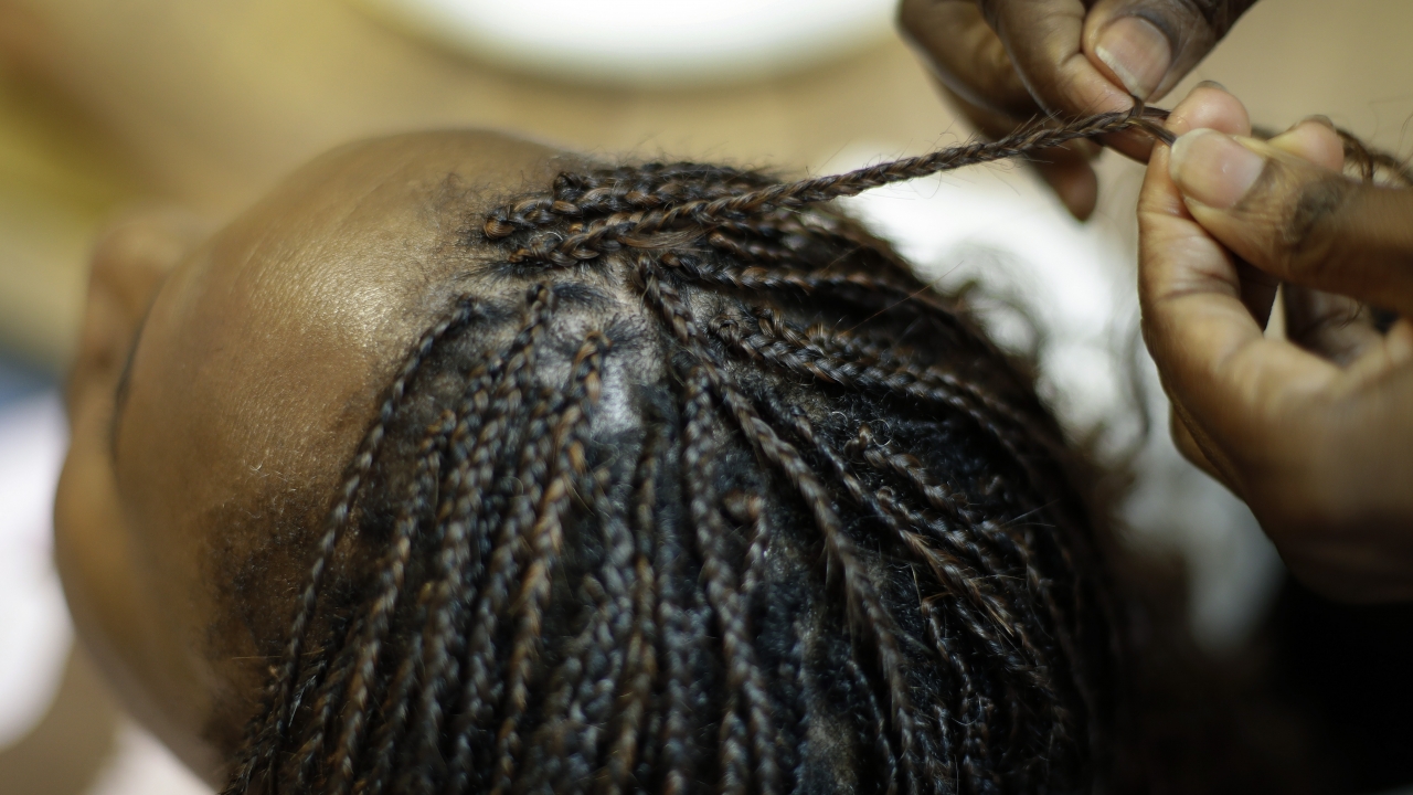 A person getting their hair braided.