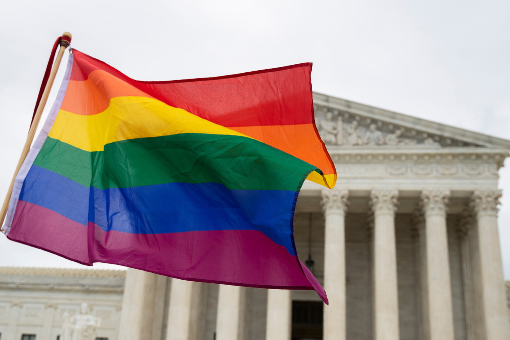 FILE - Supporters of the LGBT wave their flag in front of the U.S. Supreme Cour, Oct. 8, 2019, in Washington. (AP Photo/Manuel Balce Ceneta, File)