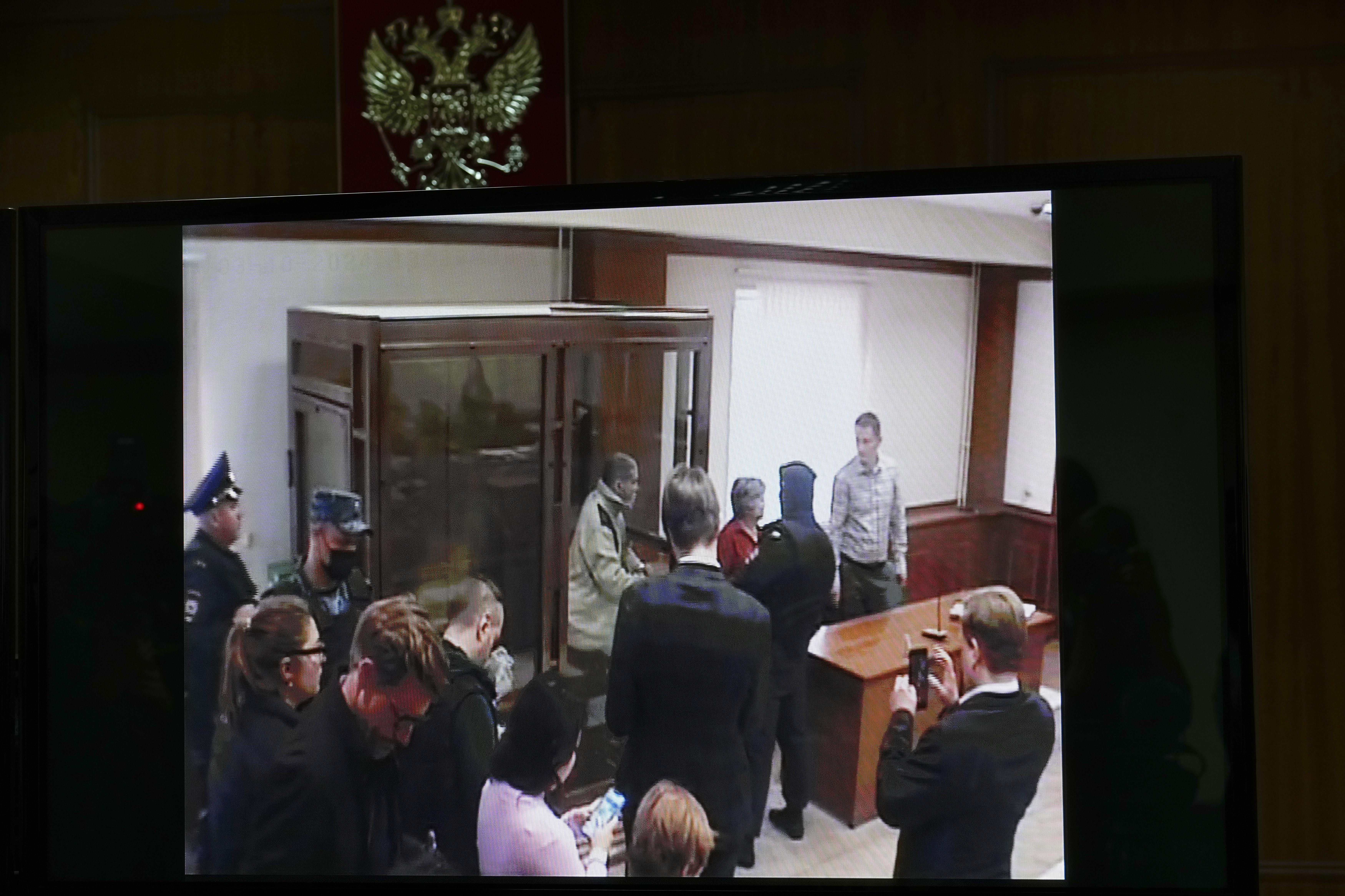 Stephen Hubbard, a U.S. citizen accused of fighting as a mercenary in Ukraine against Russia shows up in a video link as he stands in a glass cage during a court session in the Moscow City court in Moscow, Russia, Monday, Oct. 7, 2024.