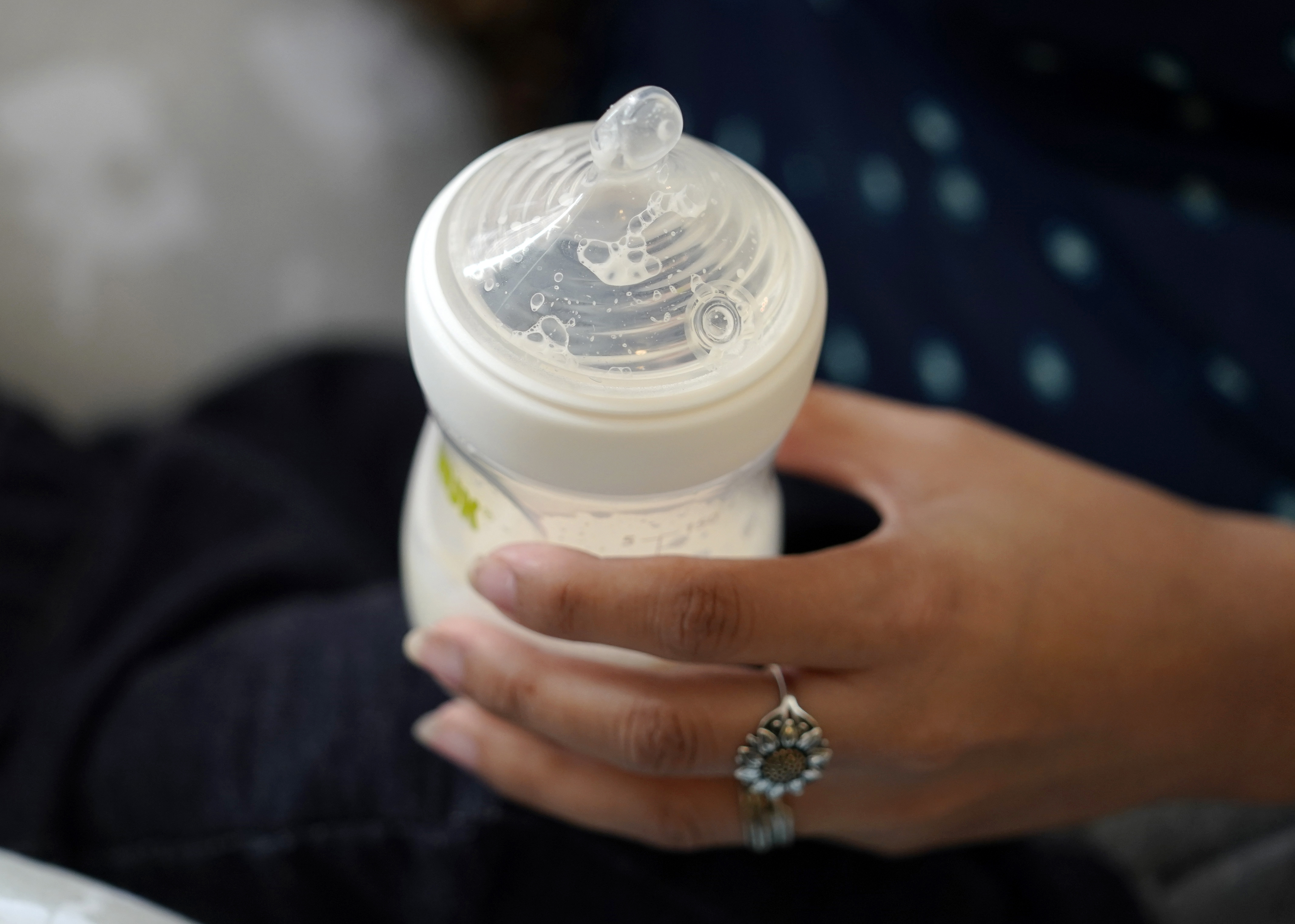FILE - A woman holds a bottle of baby formula as she feeds her infant son in San Antonio on May 13, 2022.