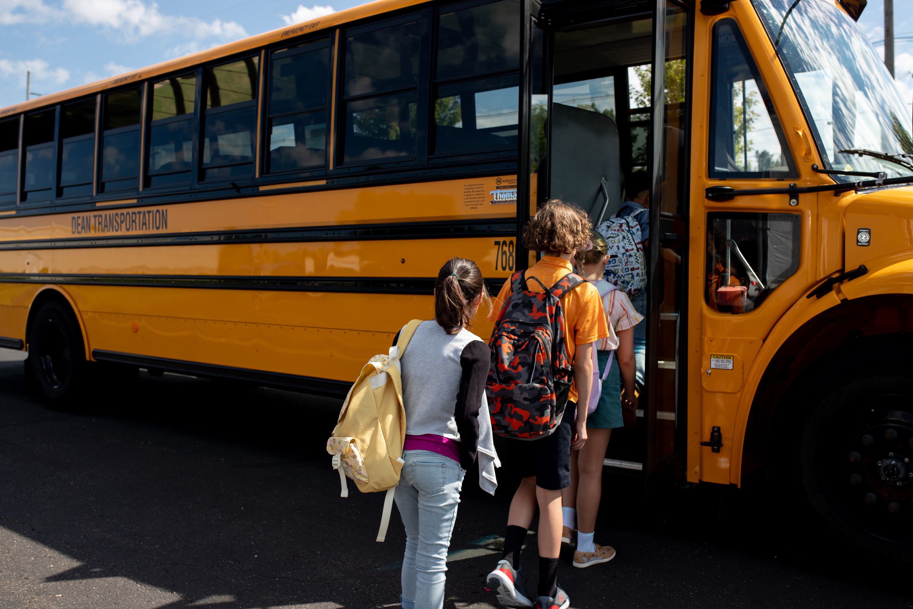 Kids getting on Dean Transportation bus