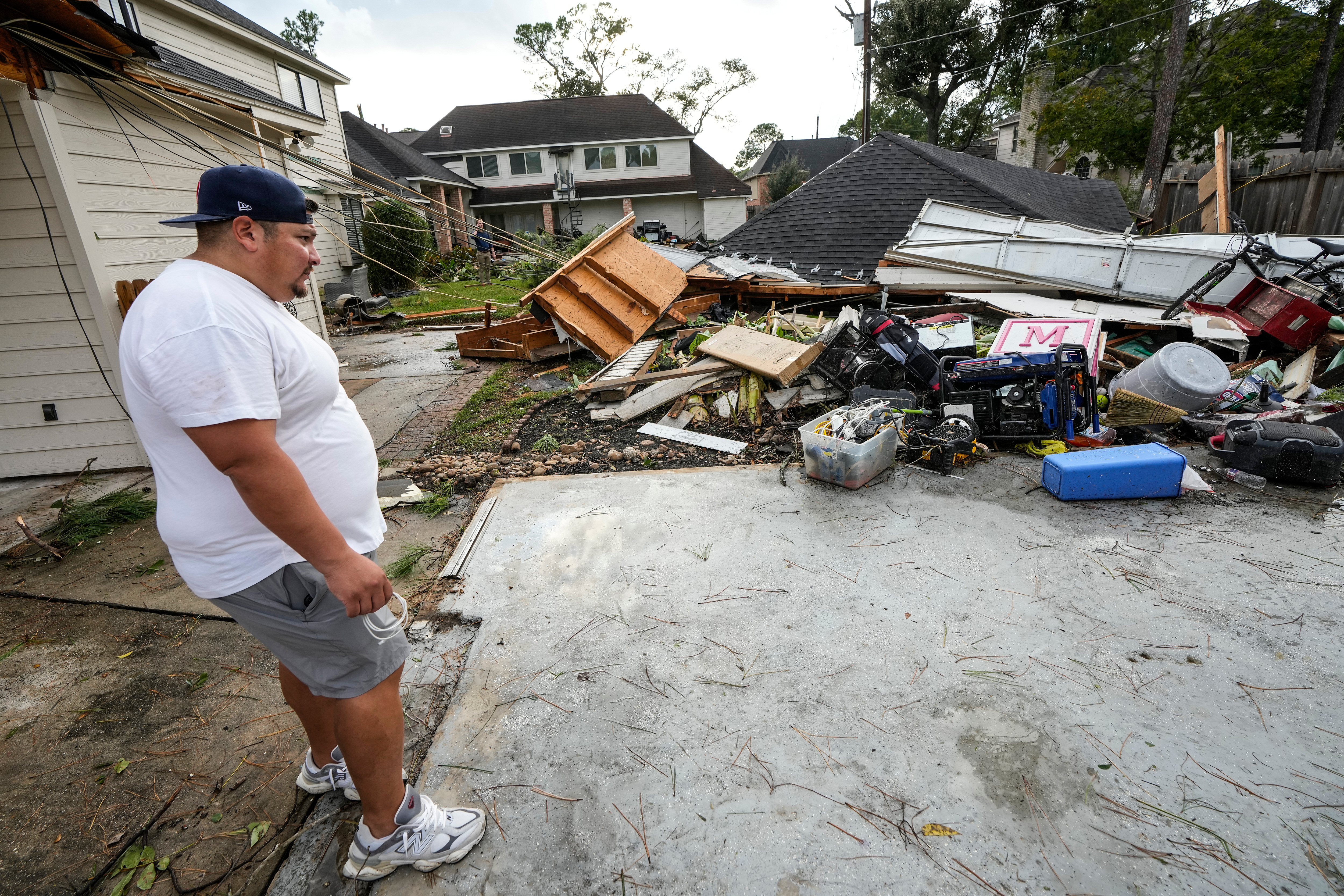 Guillermo Vargas surveys damage to his home, where his garage was swept off its foundation, while cleaning up storm damage after severe weather hit in the Memorial Northwest subdivision, in Spring, Texas, Monday, Nov. 24, 2025. 