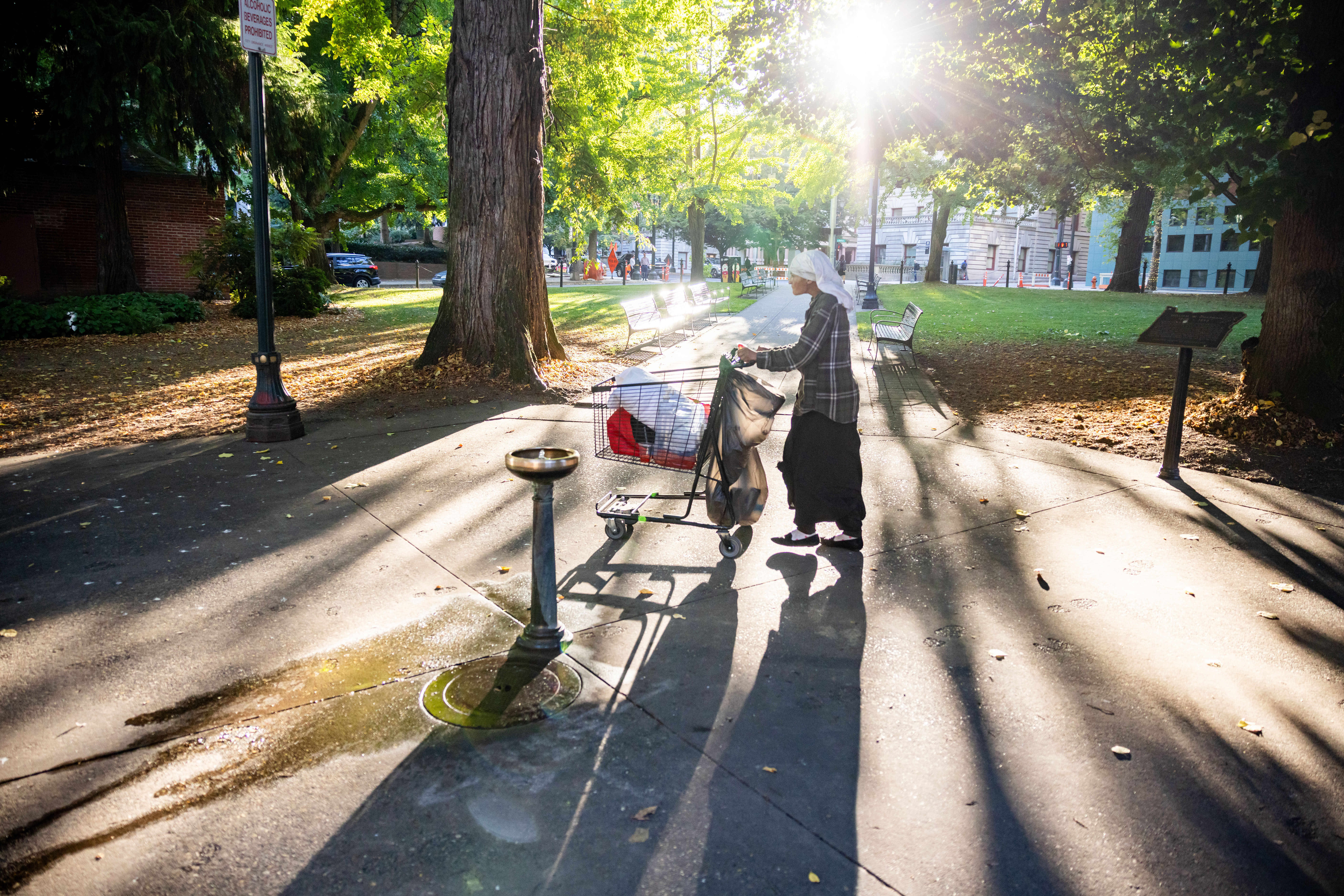 A homeless person pushes a shopping cart on Tuesday, Oct. 7, 2025, in Portland, Ore. 