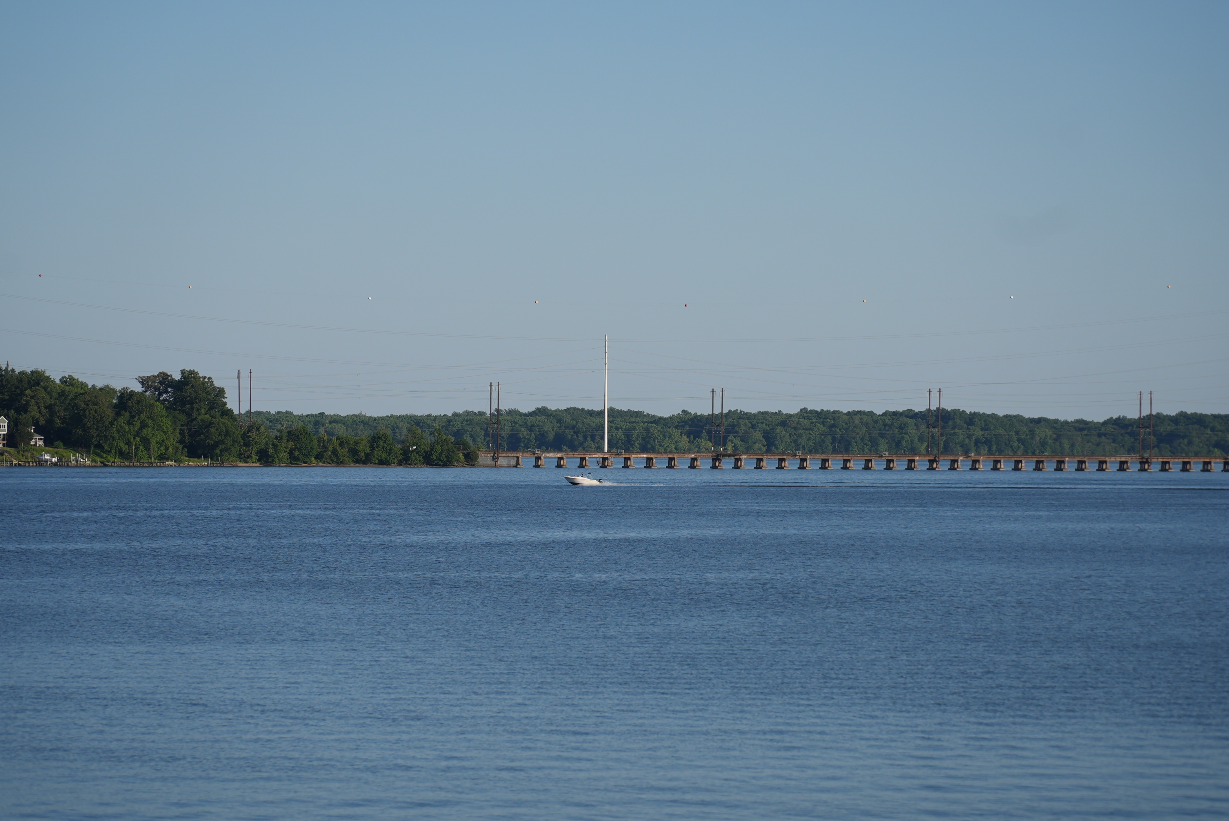 A boat riding in front of the Bush River Bridge