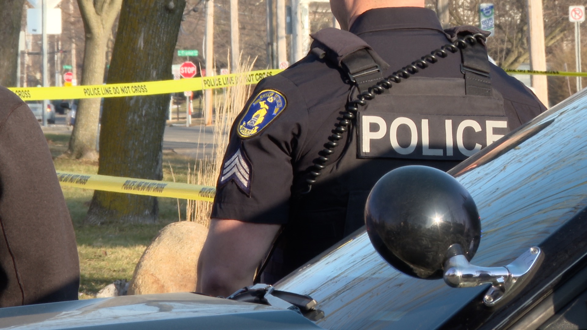 Lansing Police officer looks on shooting scene at Pete's Hy-Grade market