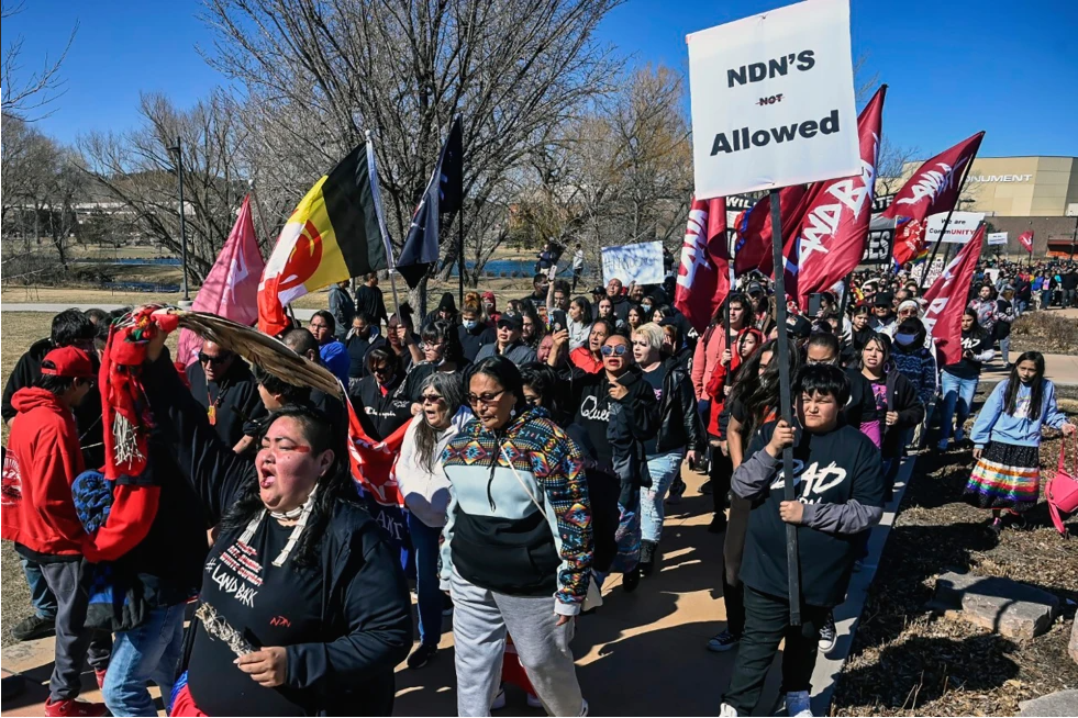 Demonstrators march from Memorial Park to the Andrew W. Bogue Federal building on Wednesday, March 23, 2022, in Rapid City, S.D., where it was announced that a federal civil rights lawsuit was filed against the Grand Gateway Hotel for denying services to Native Americans.