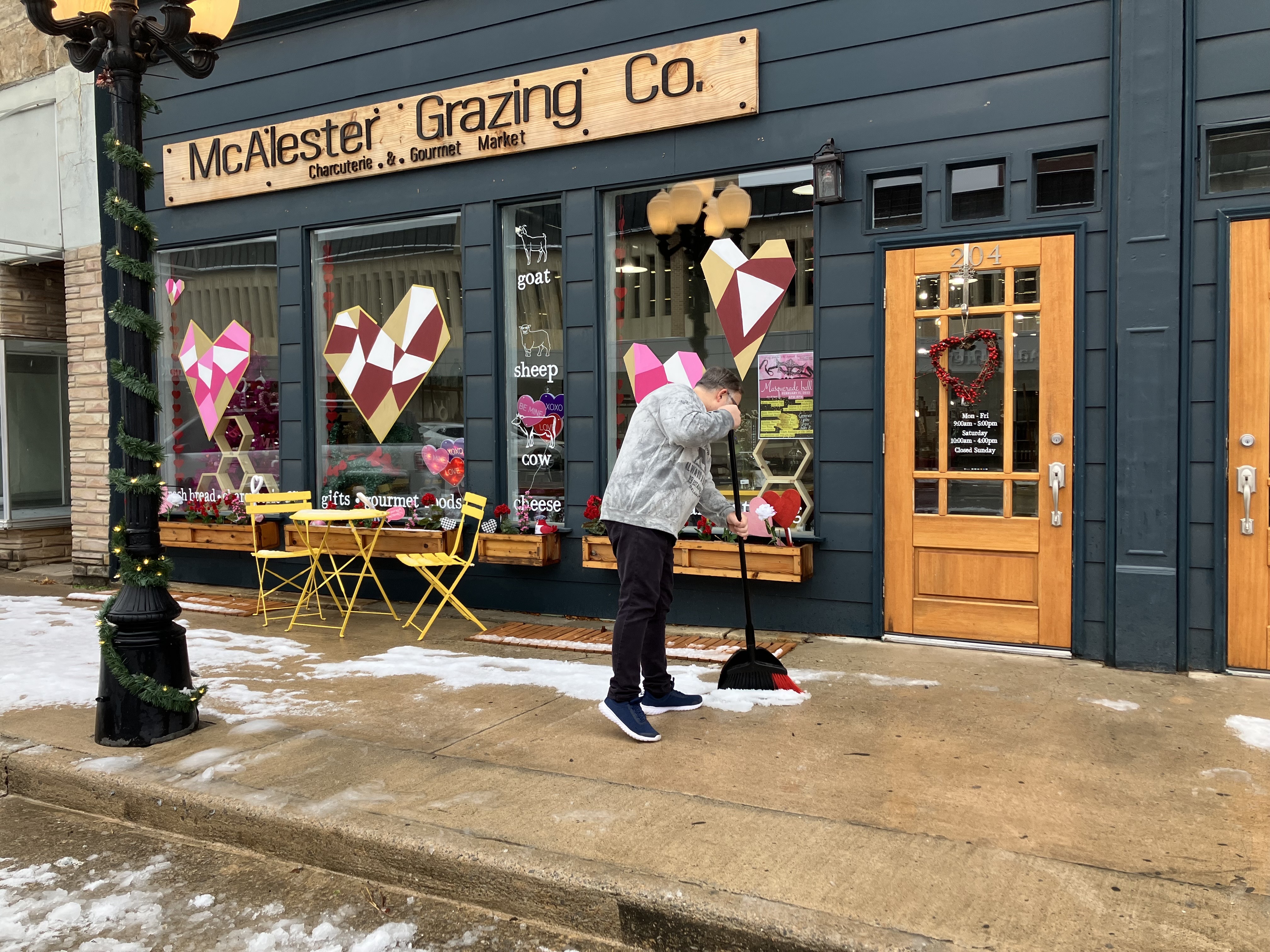 McAlester Grazing Co. employee sweeps snow off sidewalk