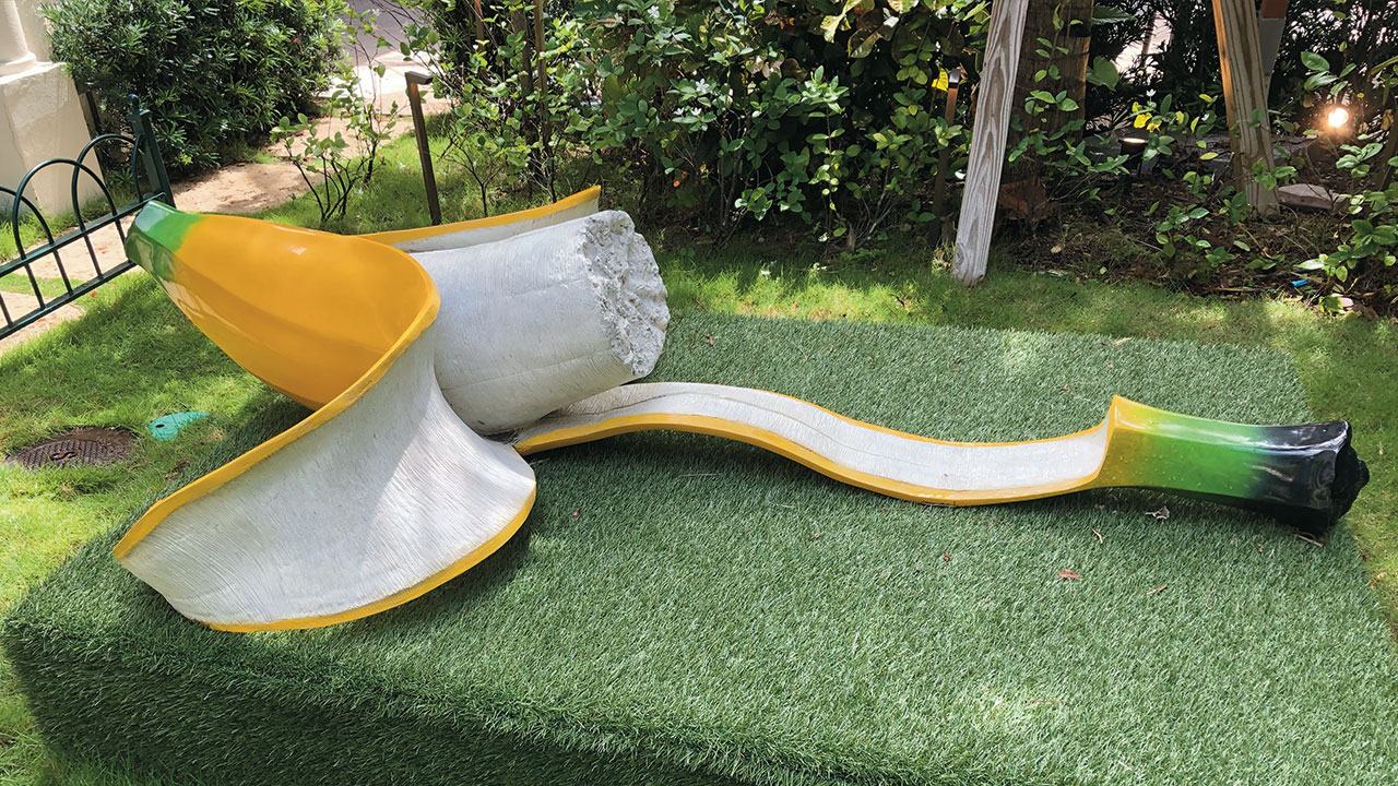 In this peaceful garden, two pieces of art are objects of unusual size created by the artist Robert St. Croix. This apple and banana are illuminated at night.