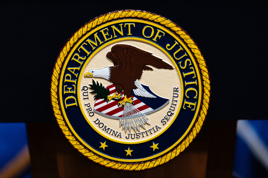 The U.S. Department of Justice logo is seen on a podium.