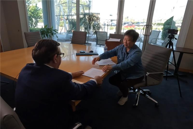 Ying Pang shows court documents to Adam Walser