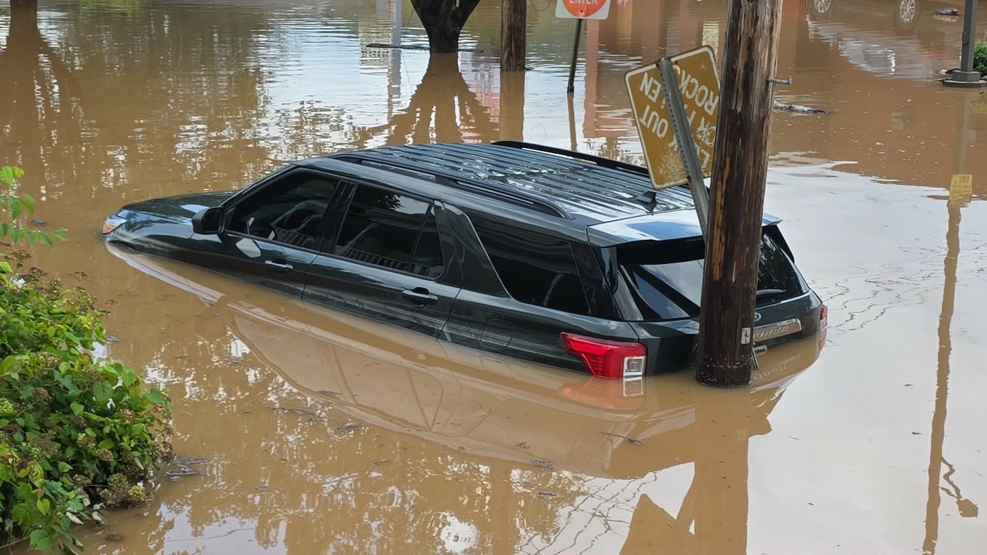A vehicle sits half-submerged in floodwaters in Buckhannon, W.Va., on Wednesday, July 22, 2026.