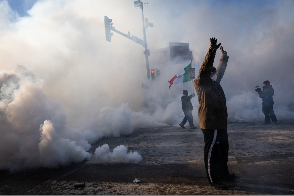 A person holds up their hands as law enforcement deploys a thick screen of teargas on Nicollet Avenue in Minneapolis on Saturday, Jan. 24, 2026.
