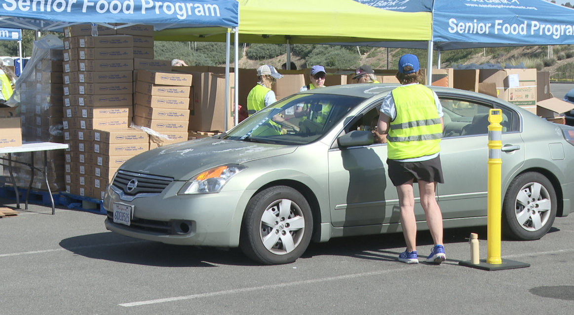 People getting food from the food distribution event at Snapdragon Stadium on Sunday.