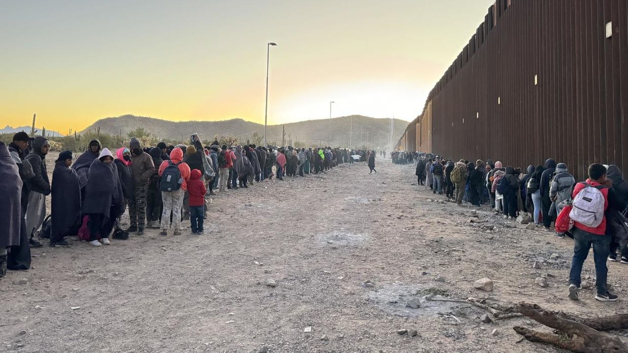 Migrants wait along the U.S.-Mexico border in Lukeville, Arizona.