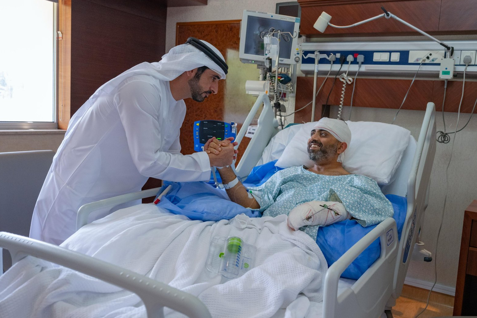 In this photo provided by the Government of Dubai Media Office, Dubai Crown Prince Sheikh Hamdan bin Mohammed bin Rashid Al Maktoum, left, visits injured Indian Flydubai Capt. Smit Machchhar at a hospital in Abu Dhabi, United Arab Emirates, Friday, Oct. 2, 2026.