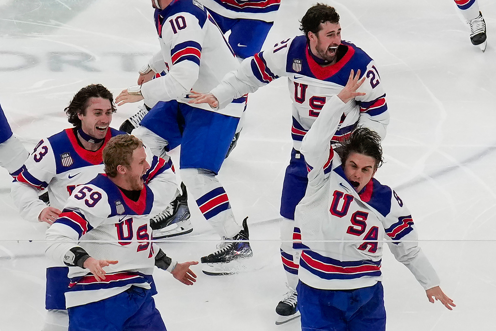 United States' Jack Hughes (86), right, celebrates with teammates after scoring the game winning goal against Canada in sudden death overtime during the men's ice hockey gold medal game at the 2026 Winter Olympics, in Milan, Italy, Sunday, Feb. 22, 2026.