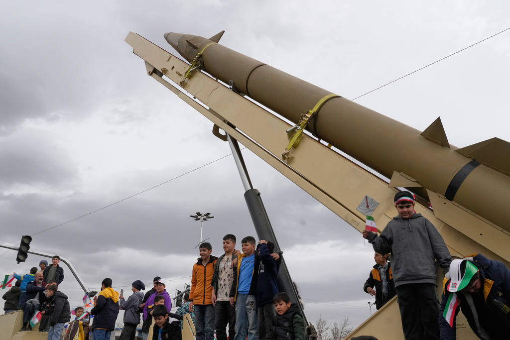 Boys stand on a launcher of an Iranian domestically-built missile during an annual rally marking 1979 Islamic Revolution at the Azadi (Freedom) sq. in Tehran, Iran, Feb. 11, 2026.