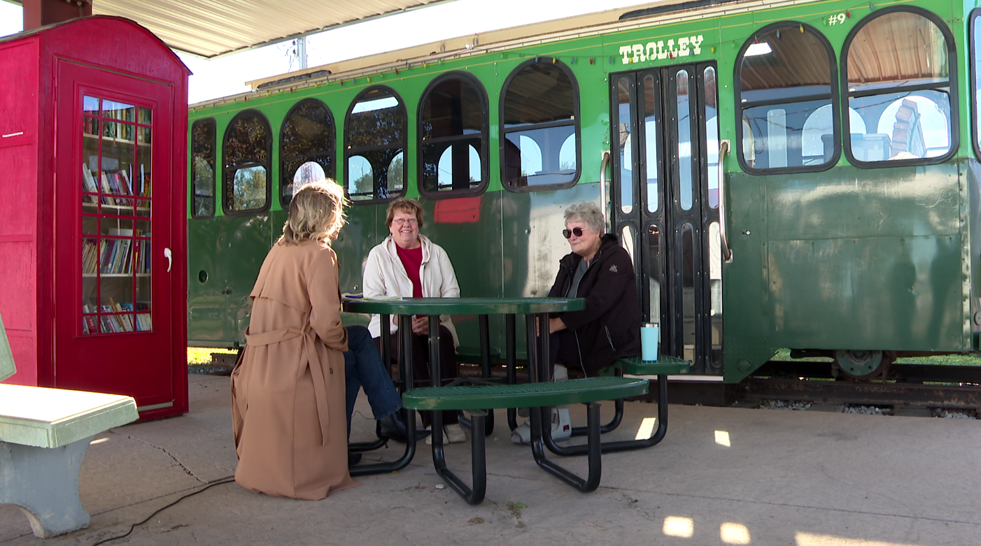 Jane Judt, center, and Marilyn Andersen, right, visit with 3 News Now's Mary Nelson in Trolley Park.