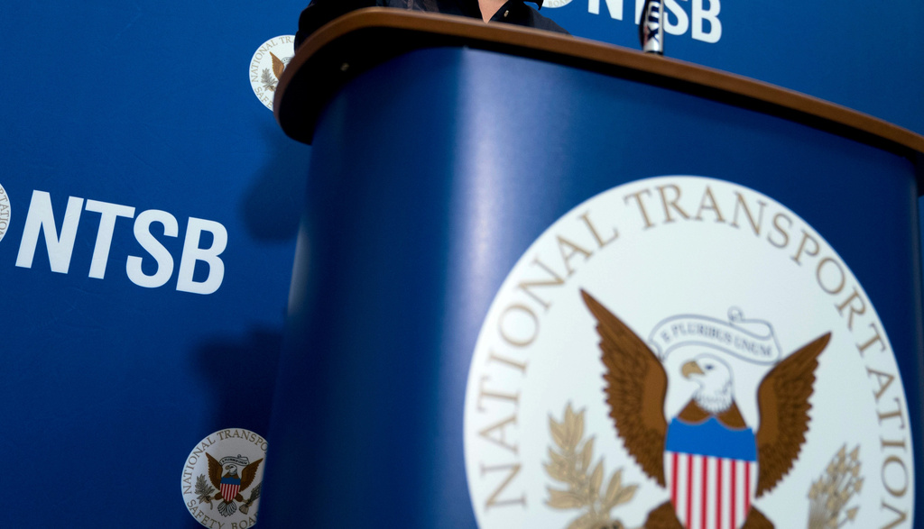 FILE - The National Transportation Safety Board logo and signage are seen at a news conference at NTSB headquarters in Washington, Dec. 18, 2017. 