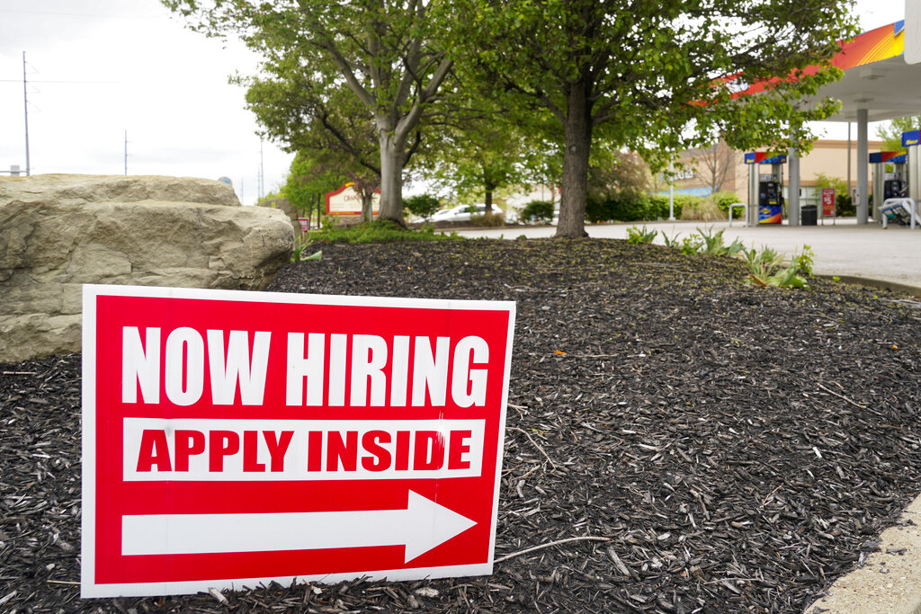 A hiring sign posted outside a business.