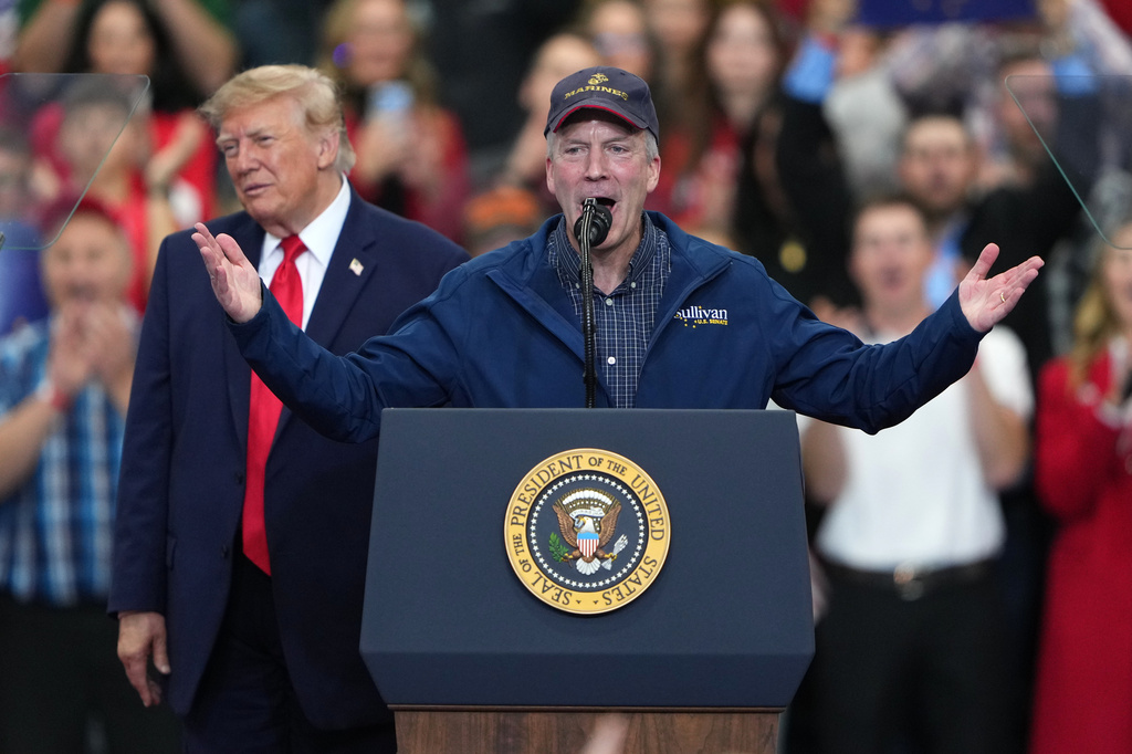 President Donald Trump listens as Sen. Dan Sullivan, R-Alaska, speaks at a campaign rally at the Curtis D. Menard Memorial Sports Center, Tuesday, Oct. 13, 2026, in Wasilla, Alaska. 