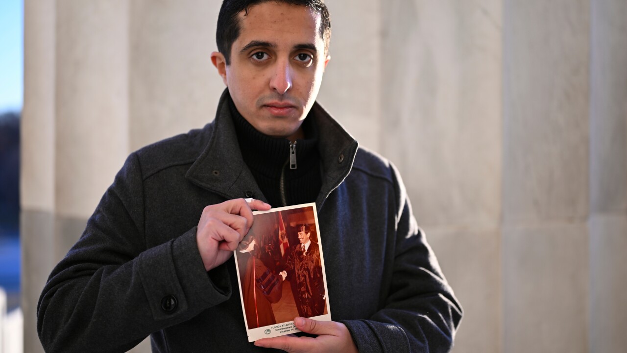 FILE - Ibrahim Almadi holds a photo of his father Saad Almadi graduating from college in 1984, in Washington, Dec. 23, 2024. (AP Photo/John McDonnell, File)