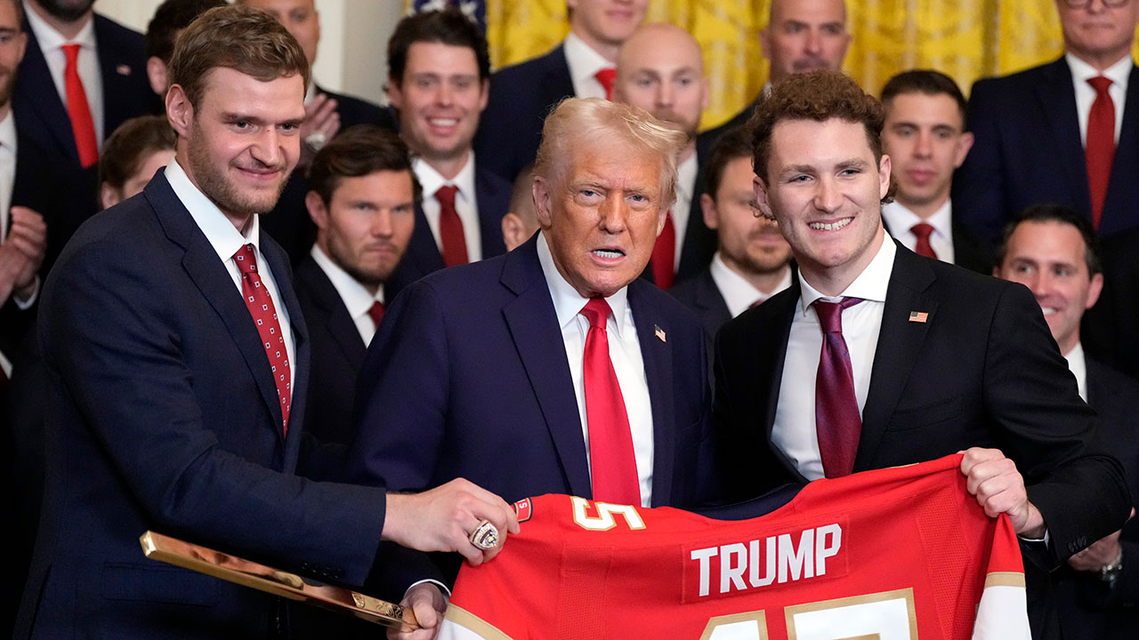 President Donald Trump poses for a photo with Aleksander Barkov, left, and Matthew Tkachuk with a jersey and a hockey stick during a ceremony with the Florida Panthers NHL hockey team to celebrate their 2024 Stanley Cup win, in the East Room of the White House, Monday, Feb. 3, 2025, in Washington. 