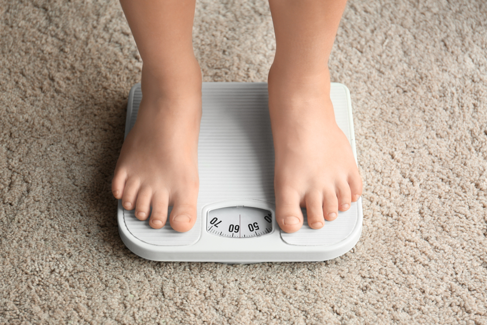 Overweight boy on  scale.