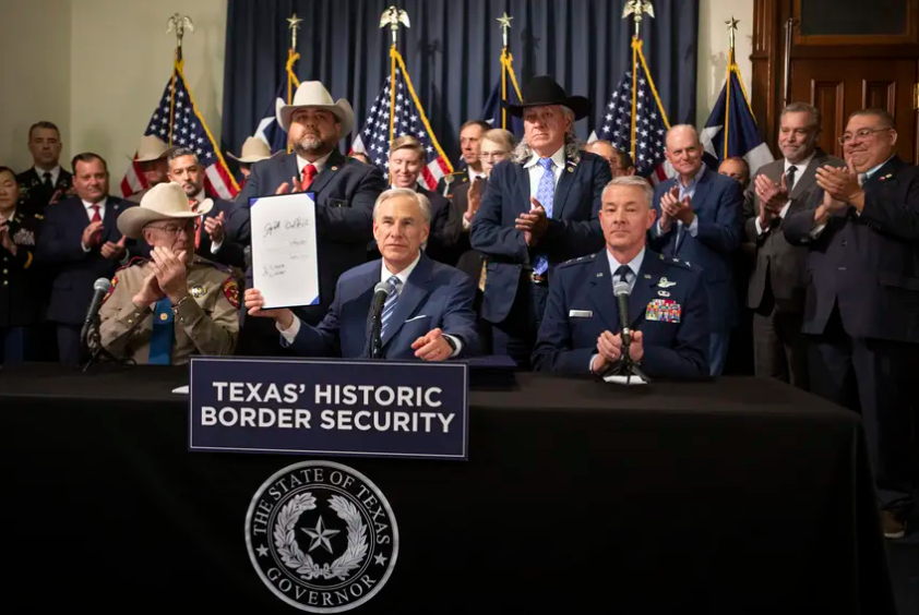 Gov. Greg Abbott displays Senate Bill 1900, one of six bills he signed during a legislation signing ceremony in Austin on June 8, 2023.