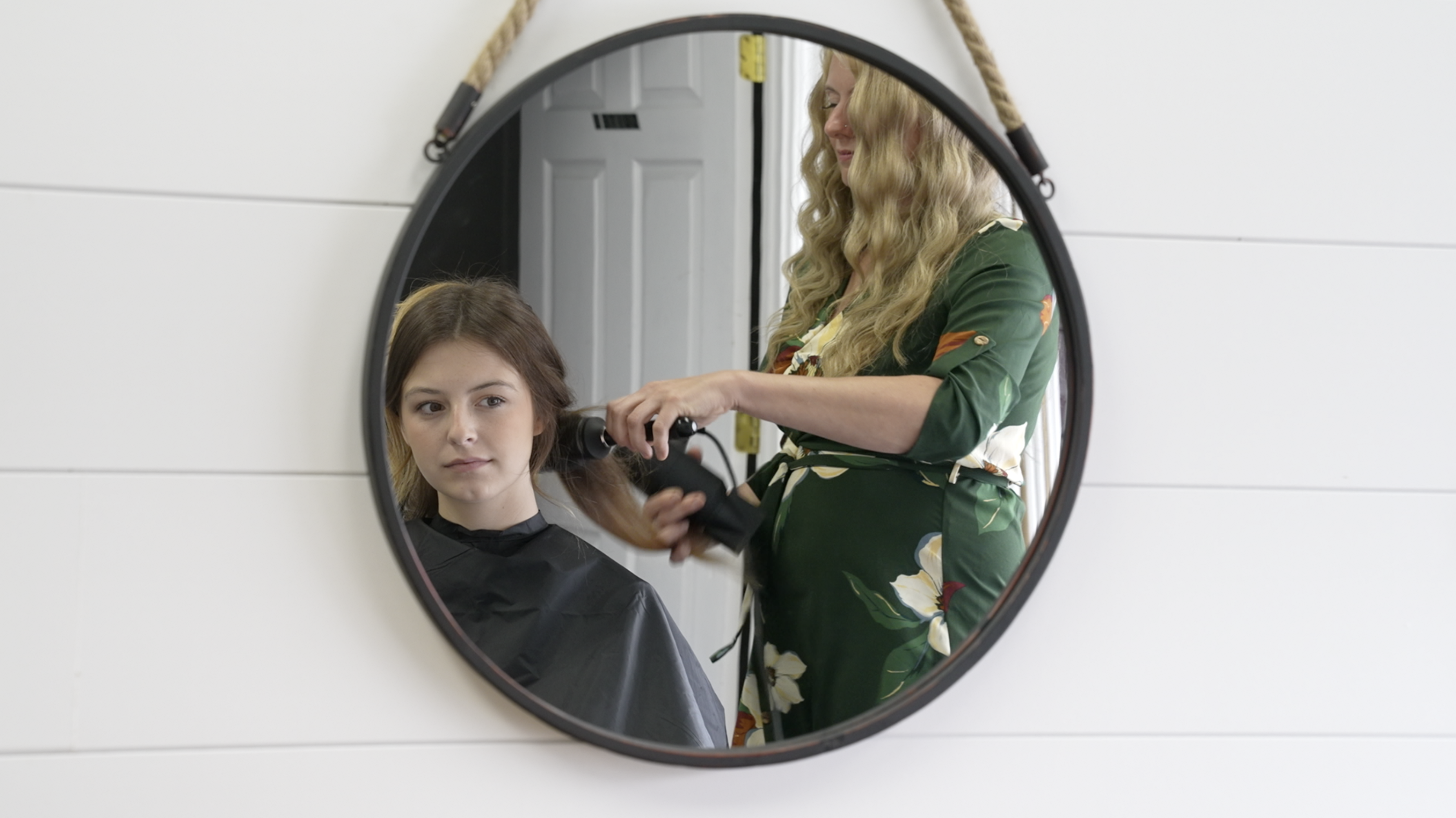 Angela Forte is blowing drying Abigail Allen's hair. 