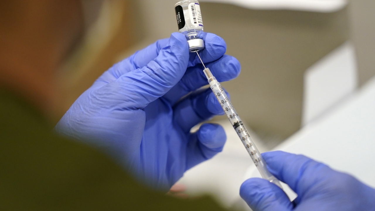 A healthcare worker fills a syringe with the Pfizer COVID-19 vaccine.