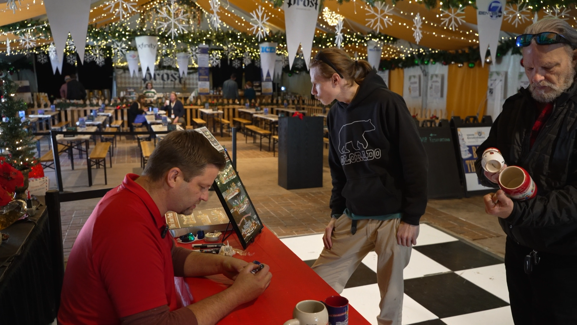 Denver Christkindlmarket illustrator signs mugs for collectors before supply runs out