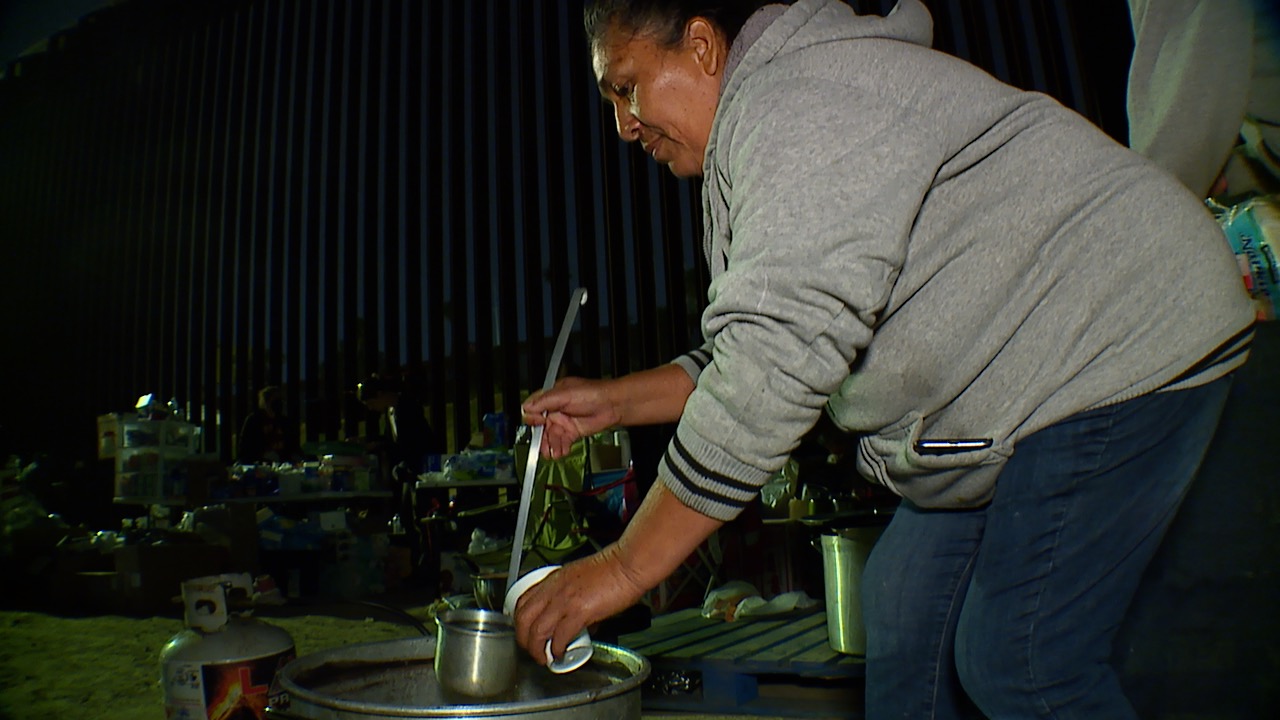 Woman cooks beans and makes coffee at the border wall near San Ysidro