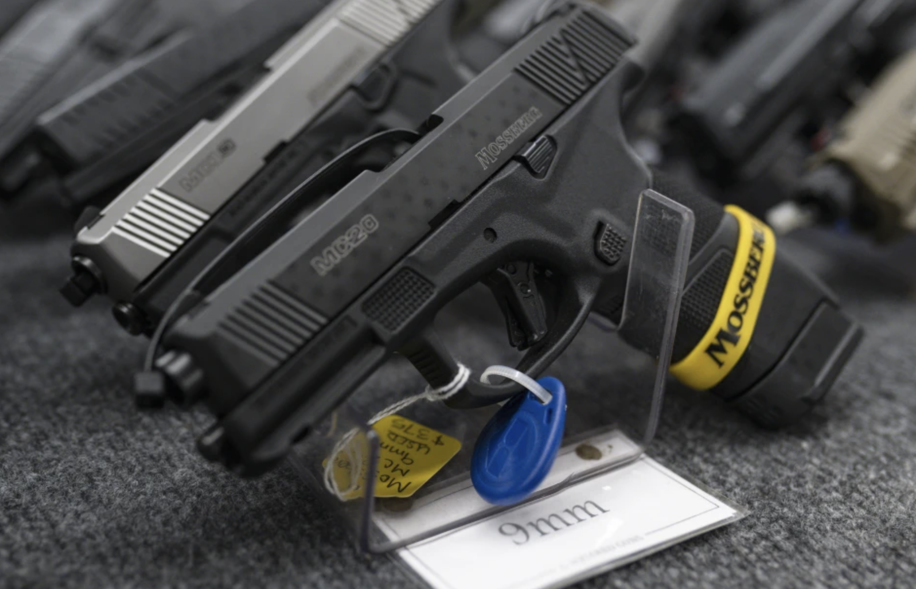FILE - Pistols sit on display during the first day of the Silver Spur Gun and Blade Show, Jan. 22, 2022, in Odessa, Texas. On Monday, May 20, 2024, a federal judge blocked the Biden administration from enforcing a new rule in Texas that would require firearms dealers to run background checks on buyers at gun shows or other places outside brick-and-mortar stores.