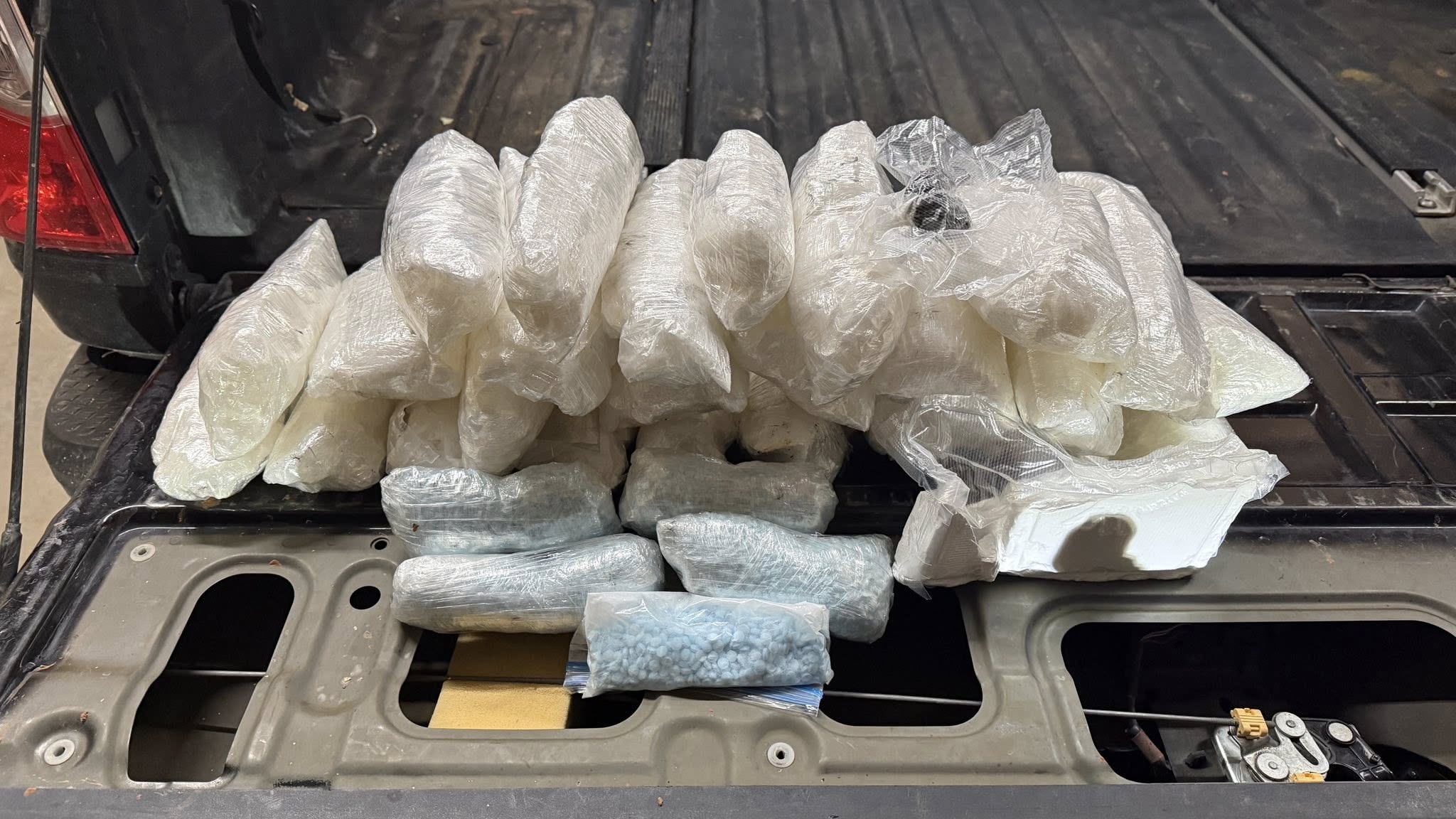 A photo of the seized narcotics released by the San Juan County Sheriff's Office. A pile of baggies filled with drugs sits on the open door of a pickup truck bed.