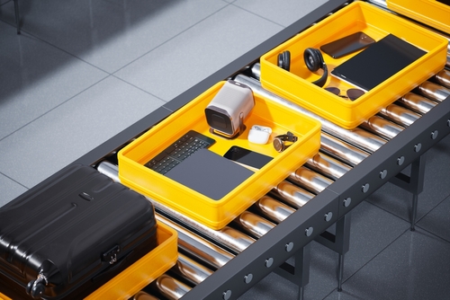 Stock image of electronic devices in sorting bins at an airport.