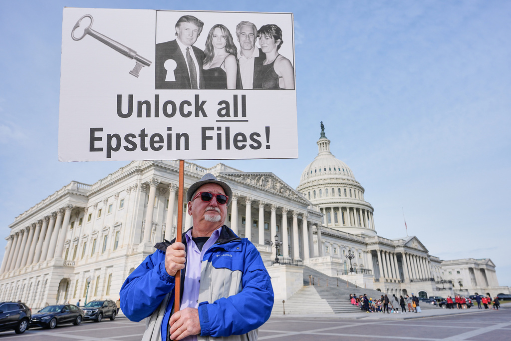 Gary Rush holds a sign before a news conference on the Epstein files in front of the Capitol, Tuesday, Nov. 18, 2025, in Washington.