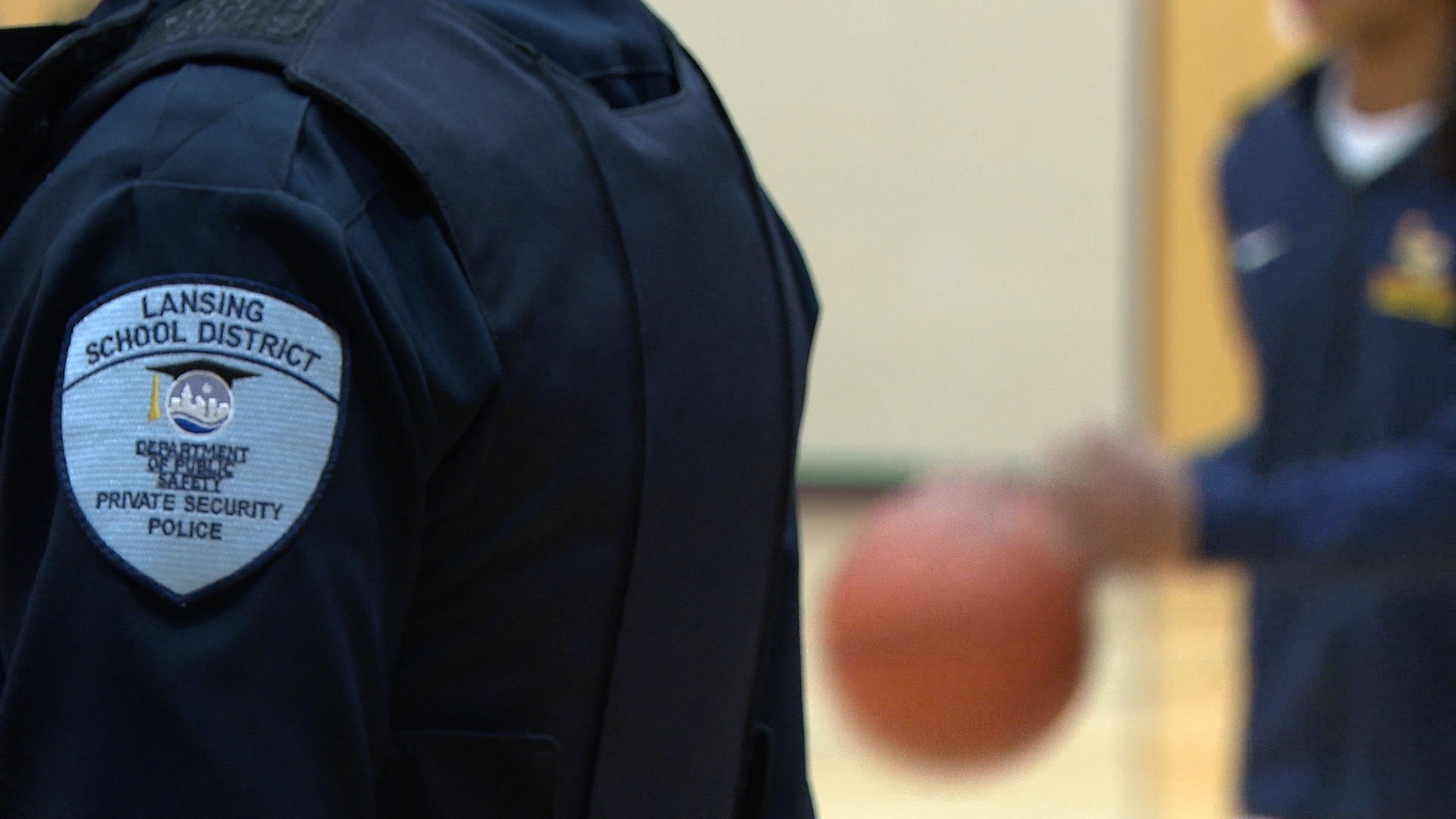 Lansing School District Patch with basketball player in background