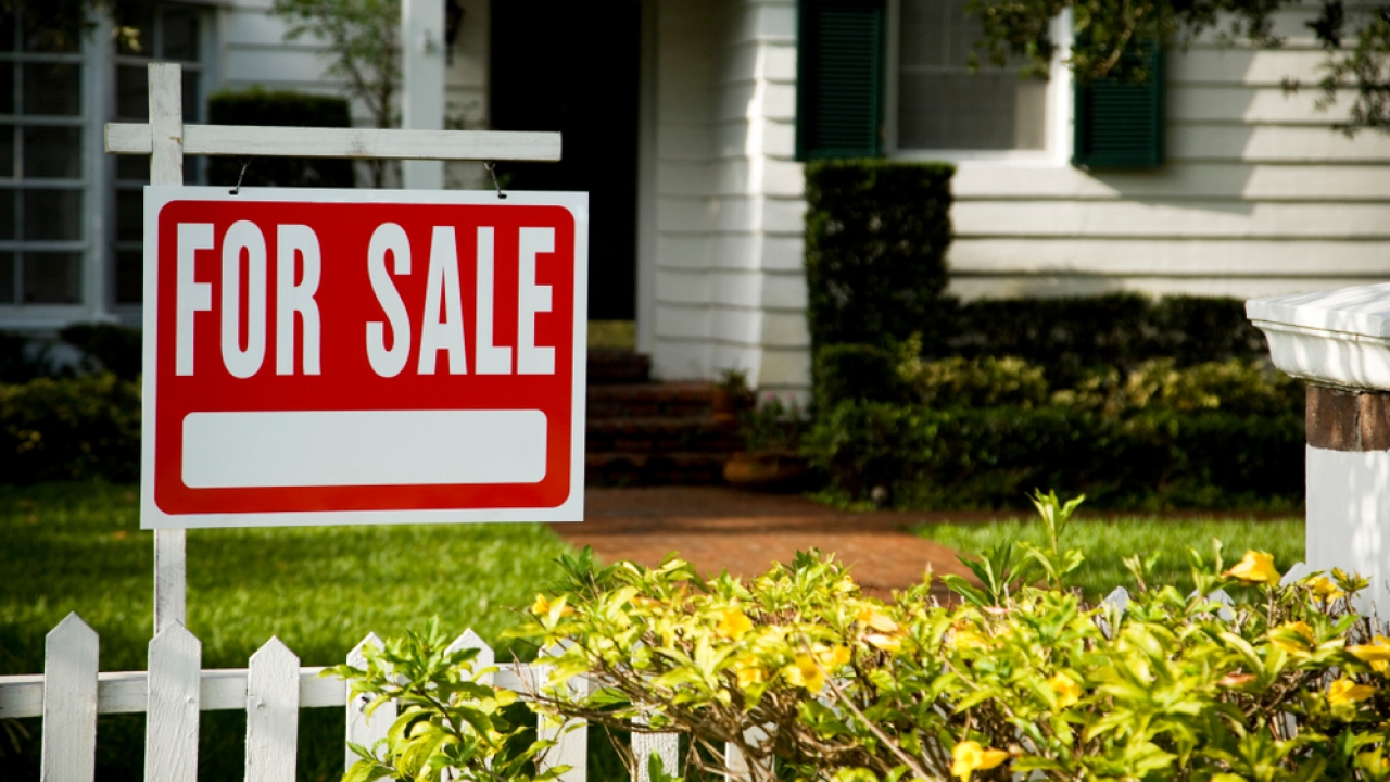 A "for sale" sign in front of a house.