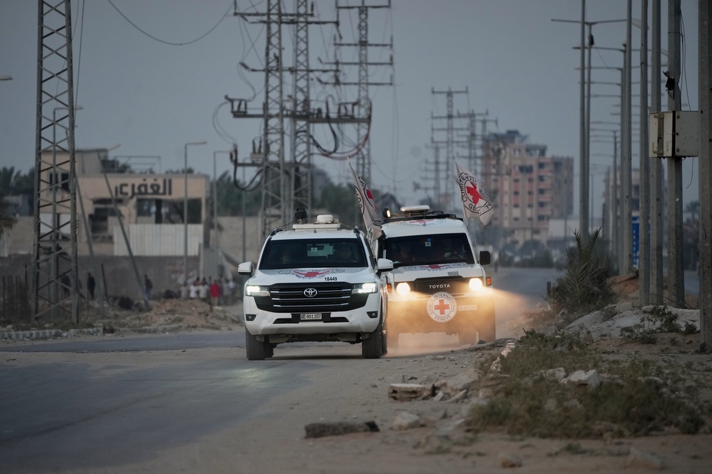 Red Cross vehicles carrying the bodies of two people believed to be deceased hostages handed over by Hamas make their way toward the Kissufim border crossing with Israel, to be transferred to Israeli authorities, in Deir al-Balah, central Gaza Strip, Thursday, Oct. 30, 2025.
